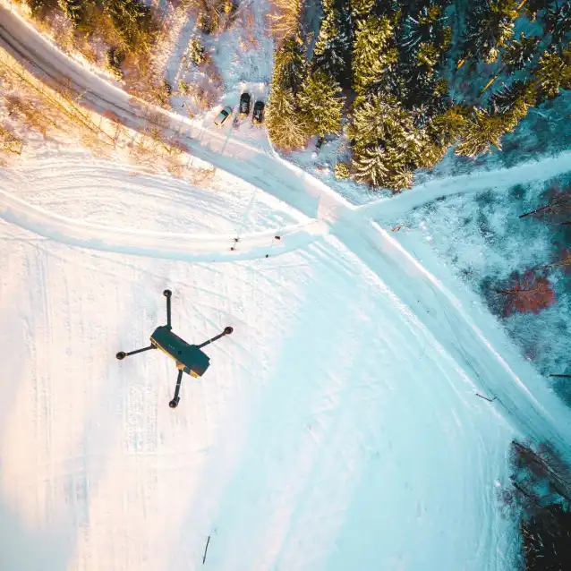 Drone hovering over snow covered land