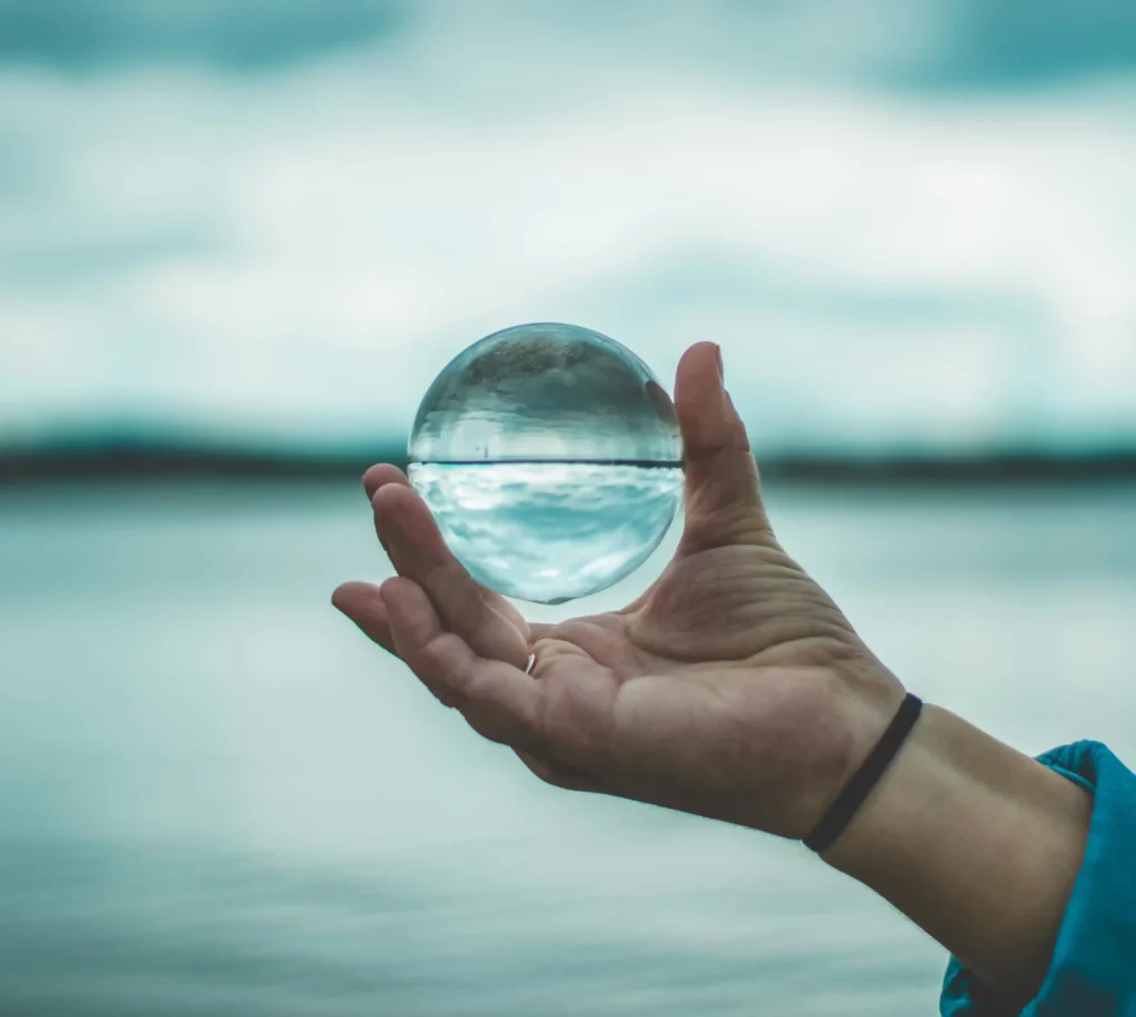 Hand holding a glass sphere